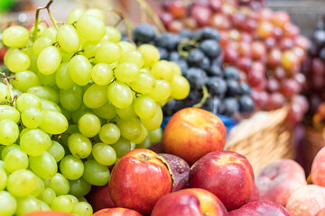 Nectarines, peaches, grapes are laid out in slides on the counter of the store