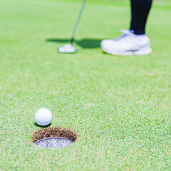 putter and golf ball on the green