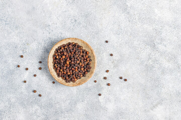 Black peppercones in a small bowl and jar.