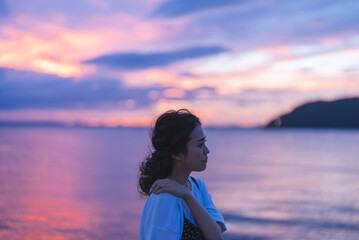 Fototapeta premium 夕暮れの海にいる女性