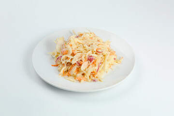 vitamin salad with carrot and cabbage closeup on white plate. fresh salad with sour cream isolated