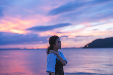 Fototapeta premium 夕暮れの海にいる女性