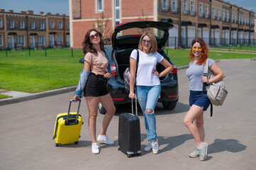 Fototapeta na wymiar Three friends are going to travel by car. Summer vacation