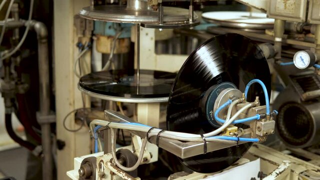 Industrial placing of vinyl record in sleeve in a record factory