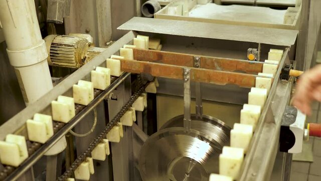 Vinyl record factory: Placing record holders in machine before machine picking them up