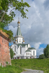 Temple of the Holy Blessed Grand Duke Alexander Nevsky on the bank of the Lithuanian stream against the backdrop of the dramatic sky in summer. Kaliningrad, Russia - 447067656