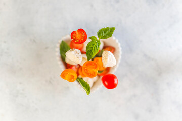 Delicious Italian Caprese salad with sliced red and orange cherry tomatoes.