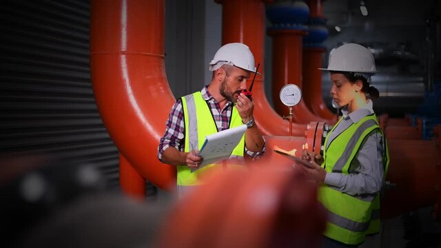 A engineer under checking the industry cooling tower air conditioner is water cooling tower air chiller HVAC of large industrial building to control air system.	