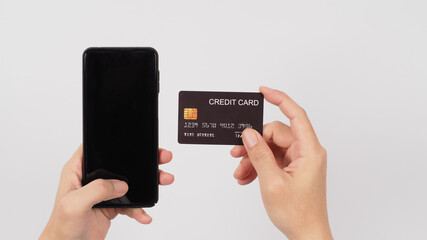 Hand is holding smart phone and black credit card on white background.