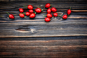 Autumn Wooden Background with red rose hip berries. Border design. Top view. Concept floral Autumn background.