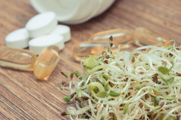 Radish sprouts containing vitamins and tablets supplements. Choice between healthy eating and pills