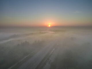 the rising sun illuminates the beautiful scenery covered with a blanket of fog