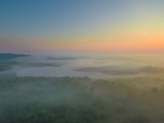 the rising sun illuminates the beautiful scenery covered with a blanket of fog