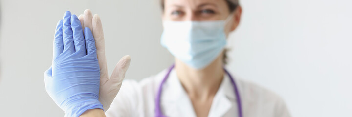 Two doctors in protective masks and gloves give each other five