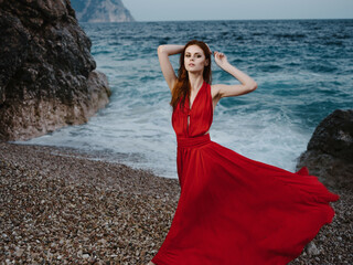 pretty woman in red dress posing near cliff beach vacation romance