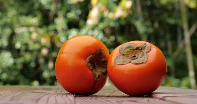 Animation of a persimmon on a wooden board. Fixed camera shooting