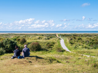 People relaxing in dunes and footpath to North Sea beach on Schiermonnikoog, Netherlands