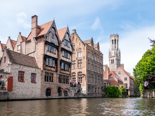 Fototapeta na wymiar Kraanrei canal with historic buildings and belfry tower in Bruges, Belgium