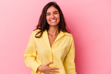 Young caucasian woman isolated on pink background touches tummy, smiles gently, eating and...