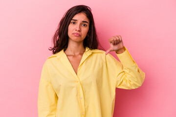 Young caucasian woman isolated on pink background showing a dislike gesture, thumbs down. Disagreement concept.