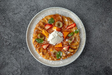 Apple pie decorated with peach and berries. Dessert. Ready menu for the restaurant. Neutral gray blue textured background.