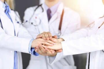 Group of modern doctors joining hands as a circle. Teamwork in medicine during Coronavirus pandemic, covid 2019