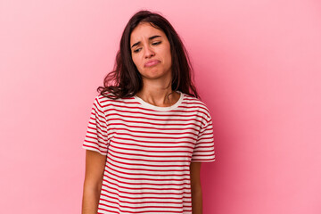 Fototapeta premium Young caucasian woman isolated on pink background shrugs shoulders and open eyes confused.