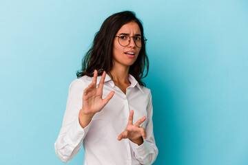 Young caucasian woman isolated on blue background rejecting someone showing a gesture of disgust.