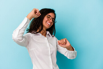 Young caucasian woman isolated on blue background celebrating a special day, jumps and raise arms with energy.