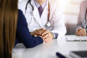 Unknown man-doctor reassuring his female patient, close-up. Perfect medical service, empathy in medicine during Coronavirus pandemic