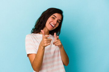 Young caucasian woman isolated on blue background pointing to front with fingers.