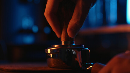 Tamping fresh coffee with neon light