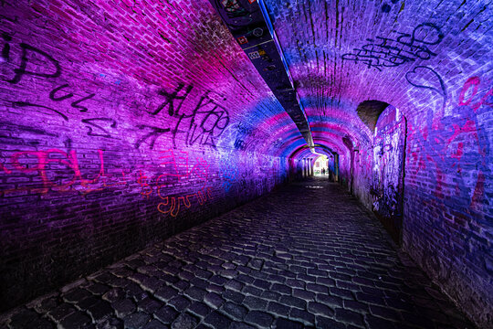 Colorfully lit tunnel from Ganzemarkt to Oudegracht in the city center of Utrecht, Utrecht Province, The netherlands