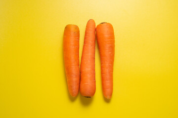 Three carrots on a yellow background