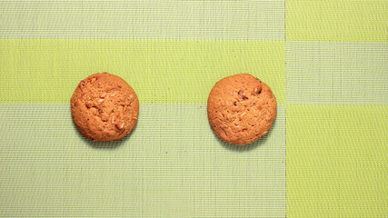 A whole round oatmeal cookie on the table surface.