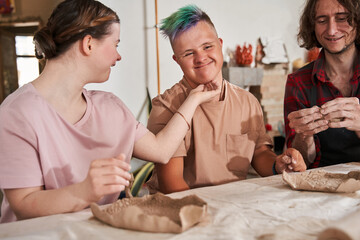 Down syndrome girl touching to the face of her boyfriend and sharing tenderness