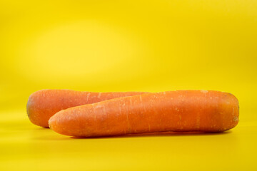 Two carrots on a yellow background
