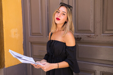 Portrait of a beautiful young woman. The woman is on holiday and is holding a map of the city she...