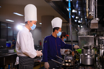 The male executive chef discussing the menu with his colleague in the kitchen.Food and restaurant concept.