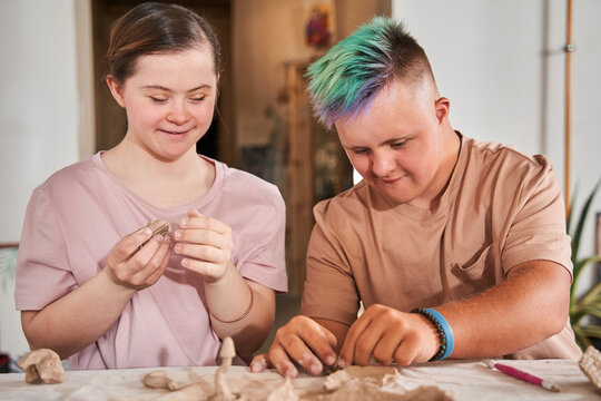 Couple of the down syndrome people feeling happy and working with clay