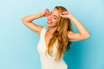 Naklejka premium Caucasian woman isolated on blue background celebrating a special day, jumps and raise arms with energy.