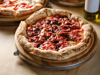 Pizza bread with pepperoni meat and red tomatoes sauce with other Italian traditional pizza assorted mix on  restaurant background 