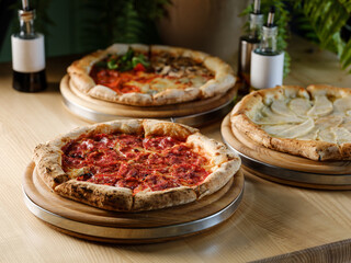 Pizza bread with pepperoni meat and red tomatoes sauce with other Italian traditional pizza assorted mix on  restaurant background 