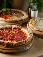 Pizza bread with pepperoni meat and red tomatoes sauce with other Italian traditional pizza assorted mix on  restaurant background 