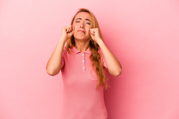 Caucasian blonde woman isolated on pink background whining and crying disconsolately.