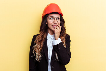 Young architect mixed race woman isolated on yellow background relaxed thinking about something looking at a copy space.