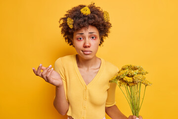 Hesitant Afro American woman shrugs shoulders looks clueless doesnt know how to cure allergy being...