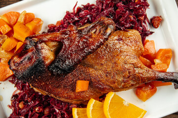 Closeup on a dish of roast peking duck with different salads