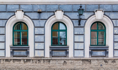 Three windows in a row on the facade of the urban historic building front view, Tallinn, Estonia
