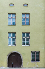 Fototapeta na wymiar Several windows and gate on the facade of the urban historic building front view, Tallinn, Estonia 